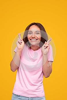 Excited woman making wish with crossed fingers