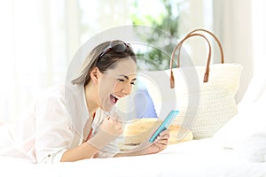 Excited woman with a phone on summer vacations