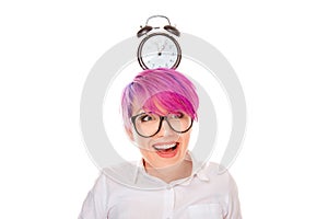 Excited woman with pink hair holding a clock on her head