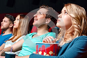 Excited woman with popcorn in cinema