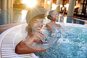 Excited woman, portrait and relax with water in jacuzzi at hotel, resort or hot tub spa together. Happy female person or
