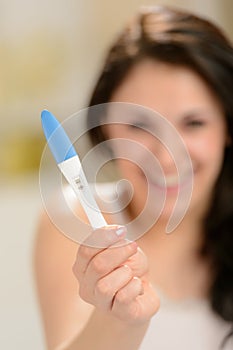 Excited woman with pregnancy test