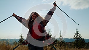 Excited woman raising hands during hike in mountains. Hiker feeling freedom