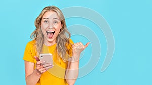 Excited woman screaming happily, holding in hand her modern smartphone