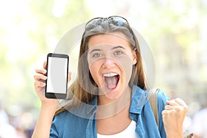 Excited woman showing a smart phone screen mockup