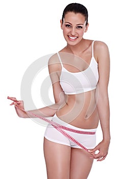 Excited woman standing with measuring tape