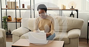 Excited woman using laptop and celebrating success holding a bundle of cash dollars