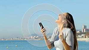 Excited woman using a smart phone in slow motion