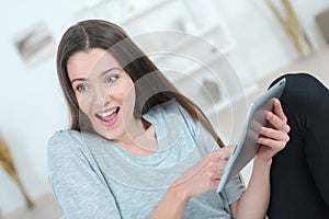 Excited woman using tablet