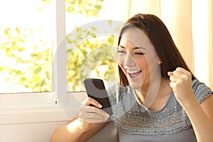 Excited woman watching content on smart phone