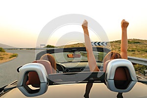 Excited women in a convertible car in the road