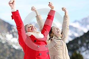 Excited women raising arms in the mountain