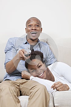 Excited young African American couple watching TV