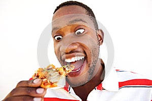 Excited young african man eating pizza