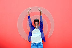 Excited young african woman standing with her arms raised