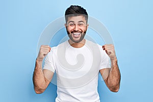 Excited young Arab man celebrating success, victory