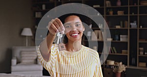 Excited young black female showing keys of new apartment