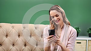 Excited young blonde woman looking on smartphone making victory gesture. 4k Dragon RED camera