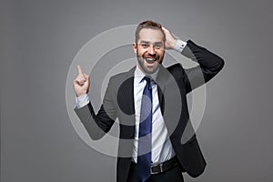 Excited young business man in classic suit shirt tie posing isolated on grey background. Achievement career wealth