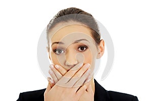 Excited young business woman covering her mouth.