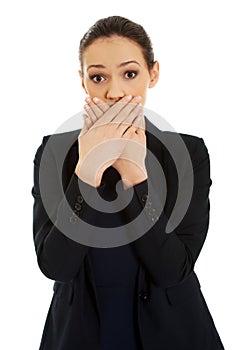 Excited young business woman covering her mouth.