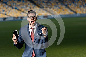 Excited young businessman in suit and