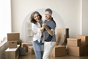 Excited young couple having fun about moving into new home