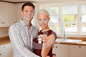 Excited Young Couple Holding Keys To New Home