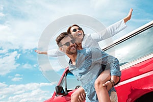 excited young couple of travelers piggybacking