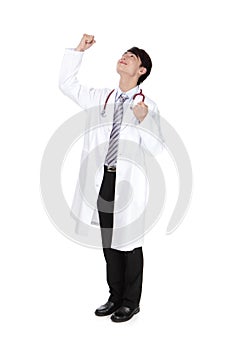 Excited young doctor rise his arm