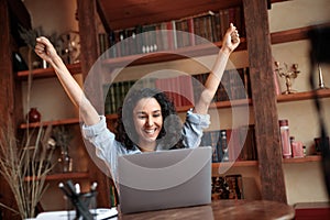 Excited young female feeling ecstatic using laptop