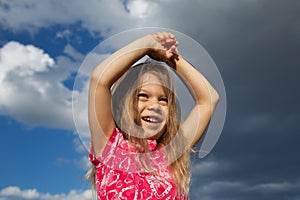 Excited Young Girl against Cloudy Sky
