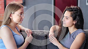 Excited young girl speaking interesting news to her female friend medium close-up