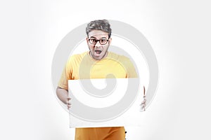 Excited Young Indian man on spectacles and showing blank poster in hand