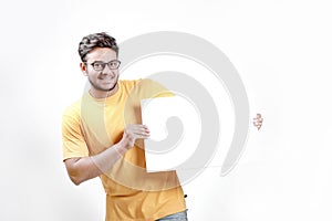 Excited Young Indian man on spectacles and showing blank poster in hand