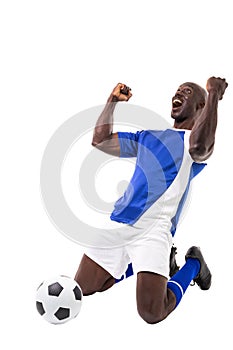 Excited young male african american soccer player celebrating after scoring goal on white background
