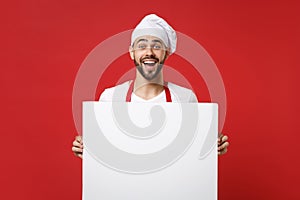 Excited young male chef cook or baker man in toque chefs hat isolated on red background. Cooking food concept. Mock up