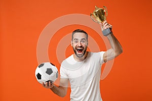 Excited young man in casual white t-shirt posing isolated on orange wall background studio portrait. People sincere
