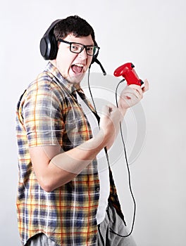 Excited young man playing video games holding a joystick isolated on gray background