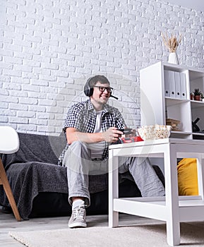 Excited young man playing video games at home enjoying his victory