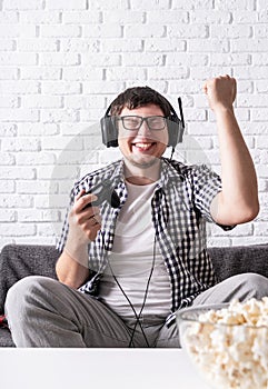 Excited young man playing video games at home enjoying his victory