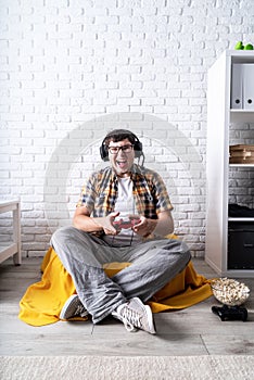 Excited young man playing video games at home enjoying his victory