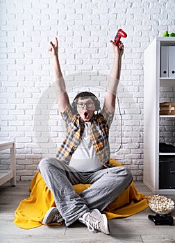 Excited young man playing video games at home enjoying his victory