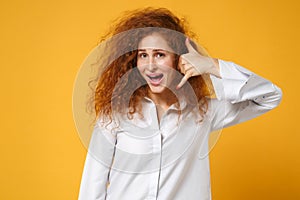 Excited young redhead woman girl in casual white shirt posing isolated on yellow orange background in studio. People
