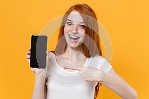 Excited young redhead woman girl in white t-shirt posing isolated on yellow background. People lifestyle concept. Mock