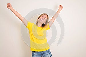 Excited young teenager girl standing isolated over white background with hands up. People, teen, emotions, expressions, success,