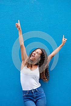 Excited young woman with arms raised