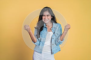 Excited young woman clenching hands while celebrating success