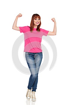 Excited Young Woman Is Flexing Muscles And Smiling