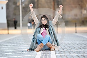 Excited young woman with hands in air